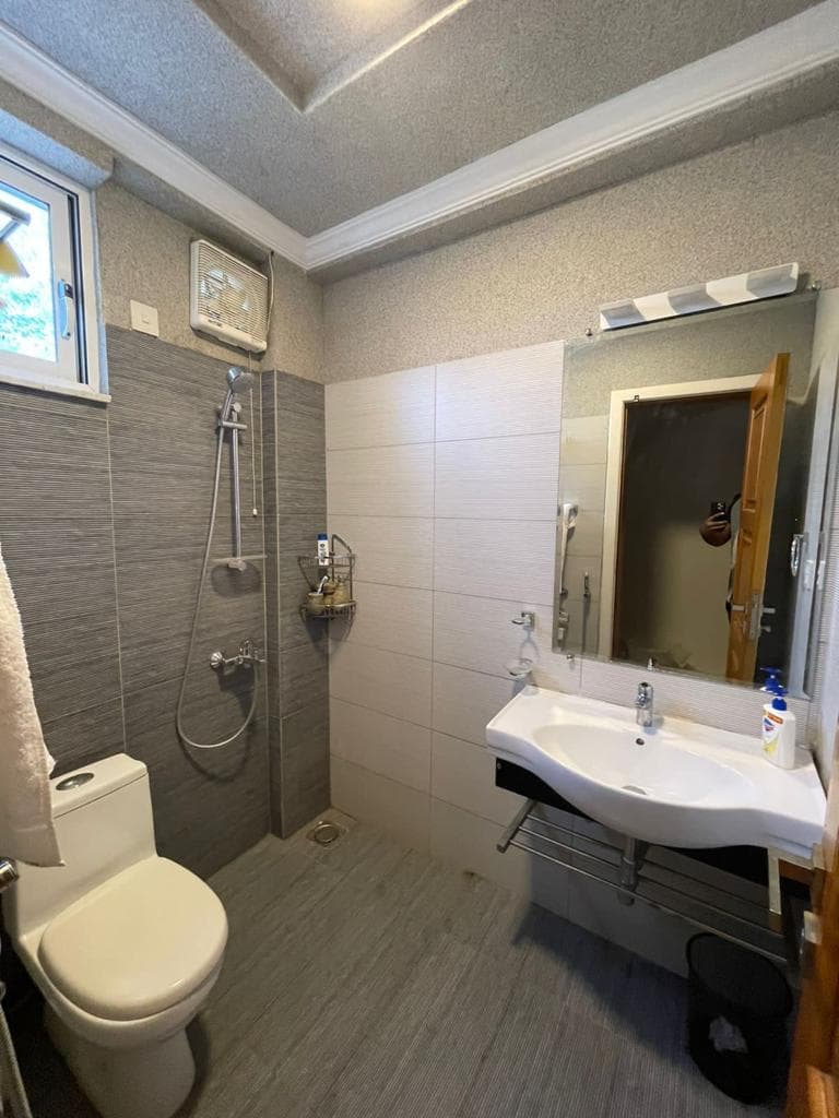 BATHROOM — stone tiles, glass shower, vanity